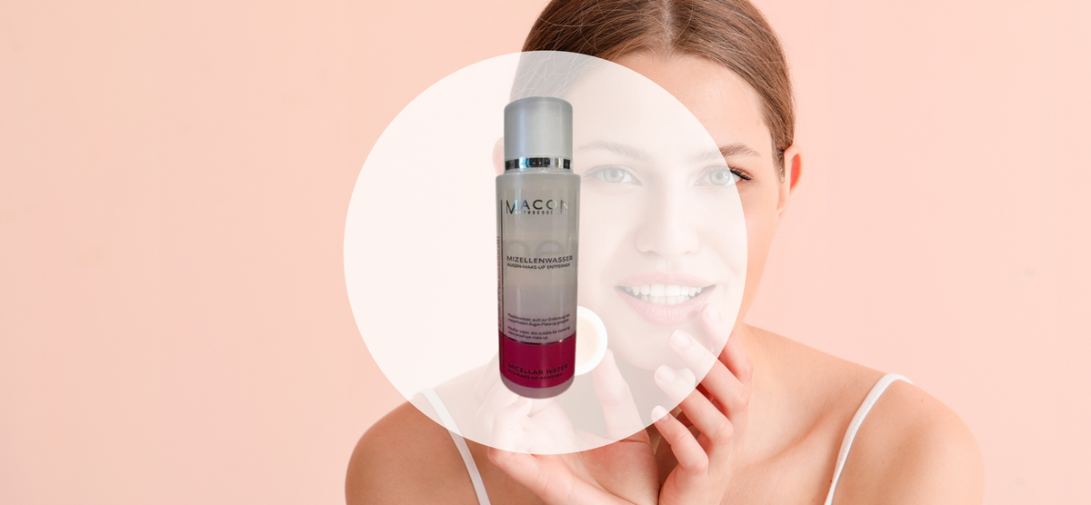 Eine Frau hält einen Flakon mit Macon Meerescosmetic Produkt, lächelnd vor einem neutralen Hintergrund.